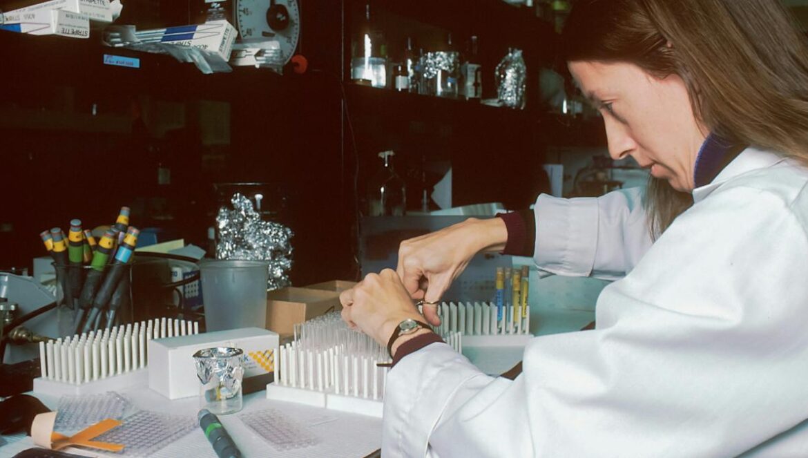 a woman in a lab coat is doing something
