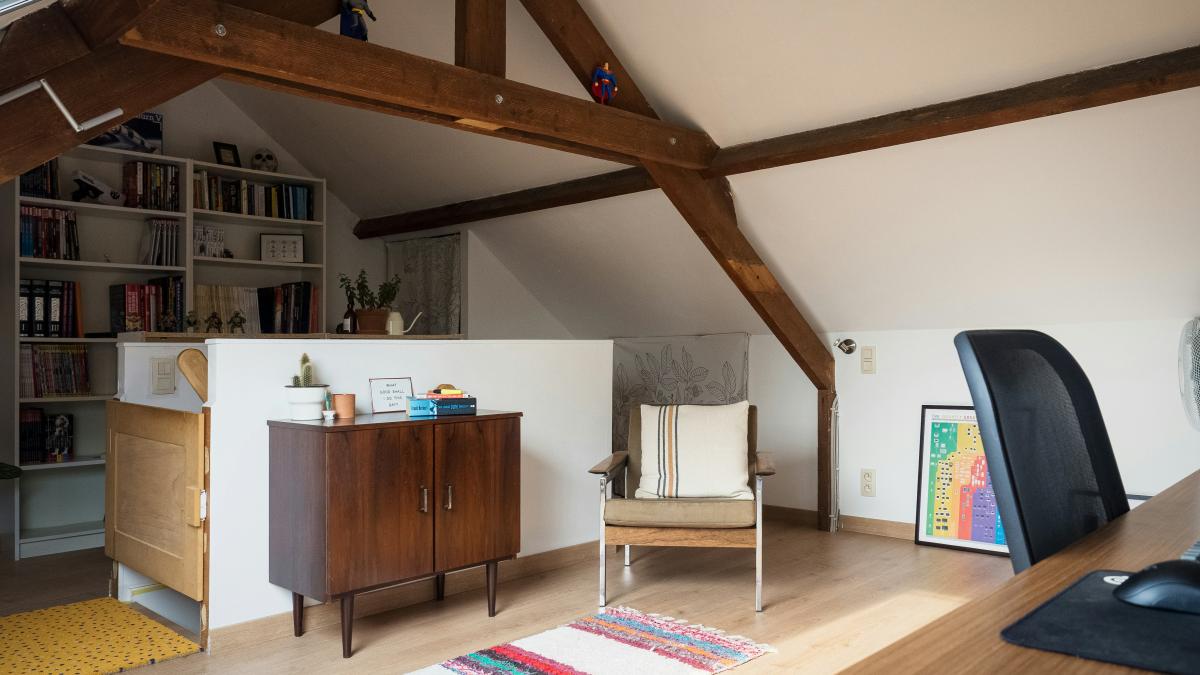 a living room with a chair and a book shelf