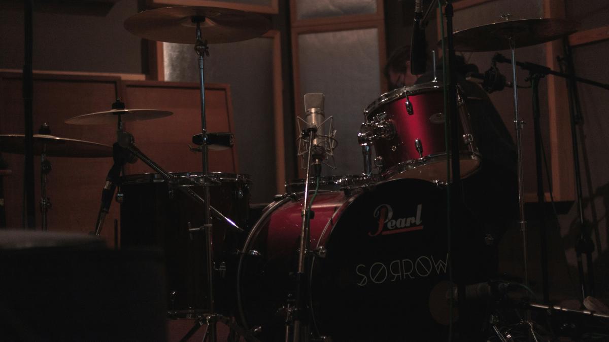 a drum set in a recording studio with sound equipment