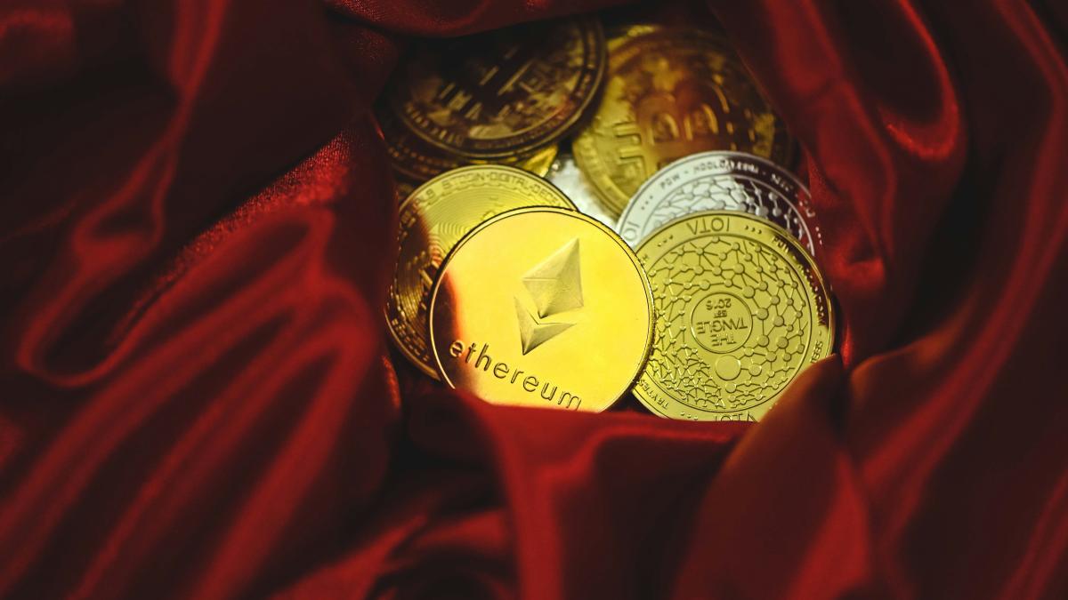 a pile of gold and silver coins sitting on top of a red cloth