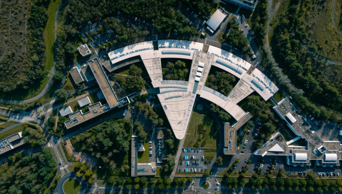 an aerial view of a circular building surrounded by trees