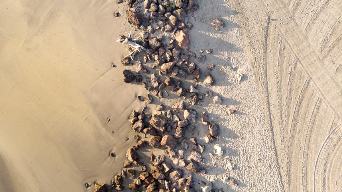 an aerial view of rocks and gravel on a beach