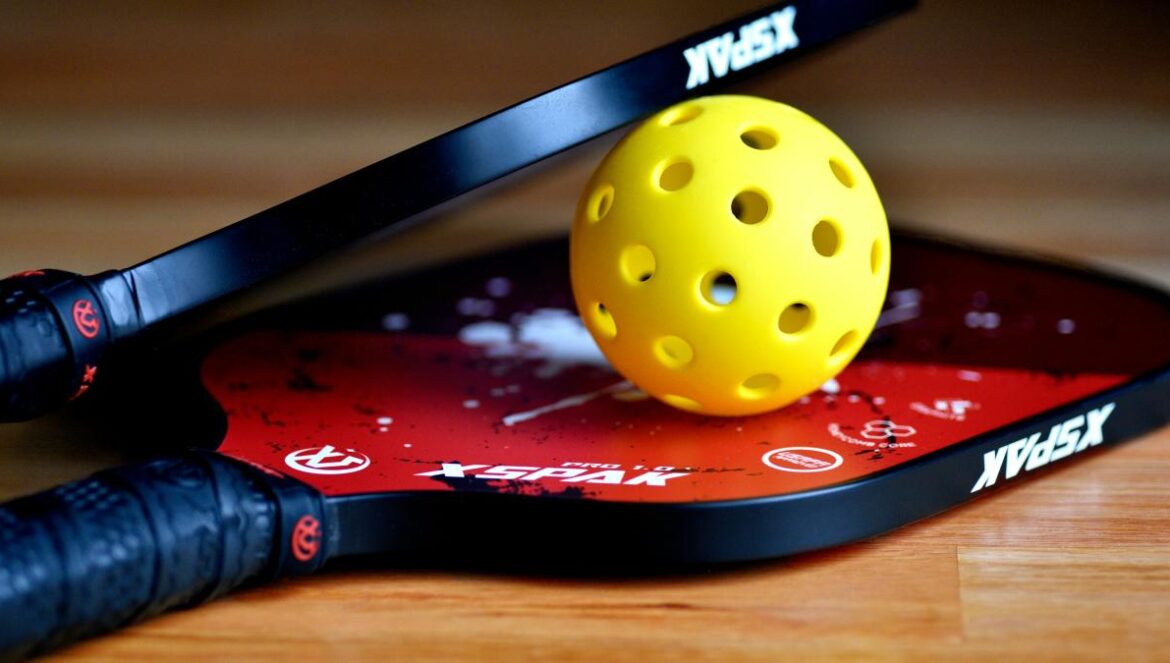 a yellow tennis ball sitting on top of a racket