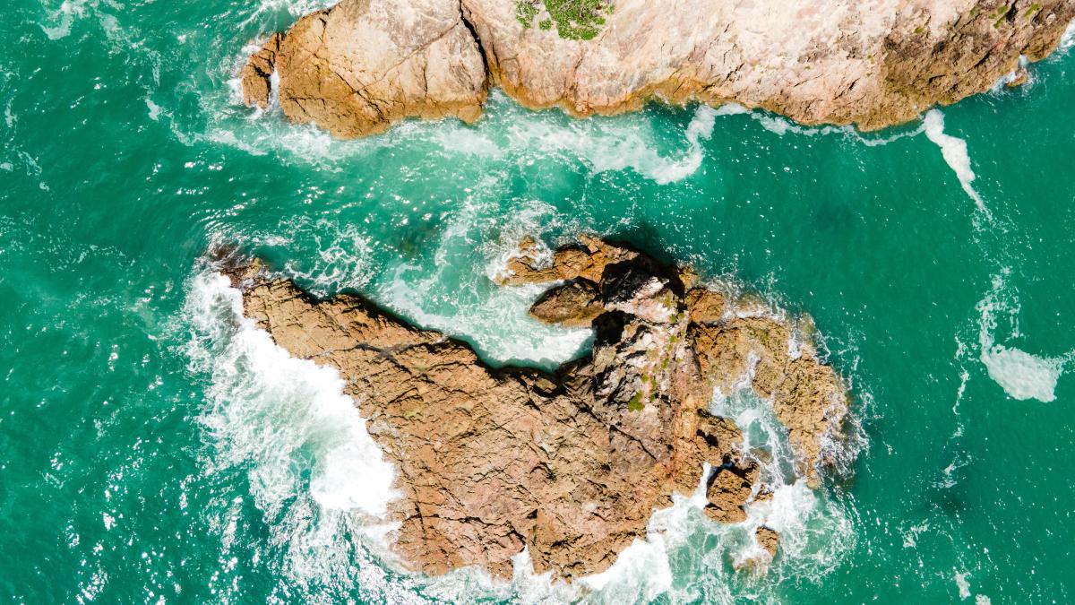 an aerial view of a rock formation in the ocean