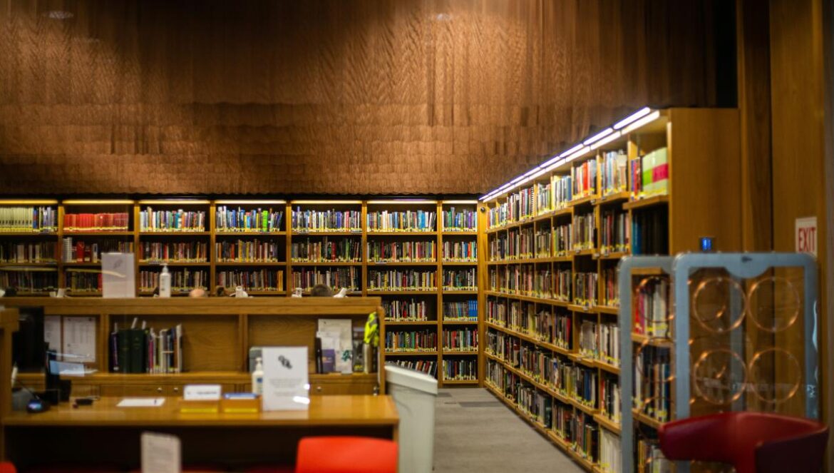a library filled with lots of books and red chairs