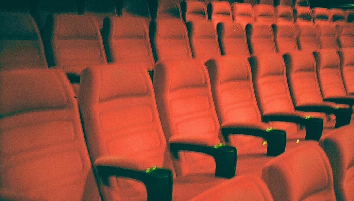 a row of empty red seats in a theater