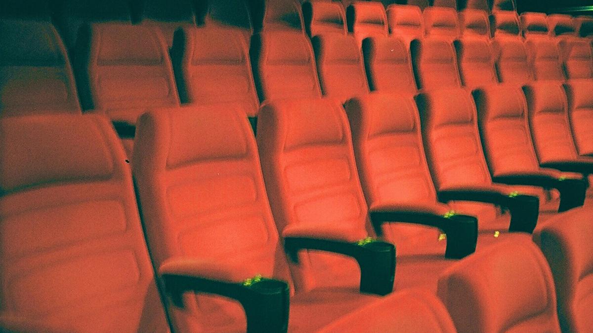 a row of empty red seats in a theater