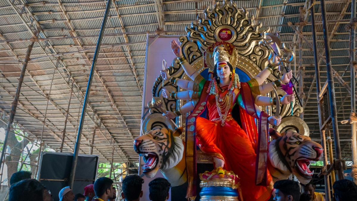 a large statue of a person sitting on top of a tiger