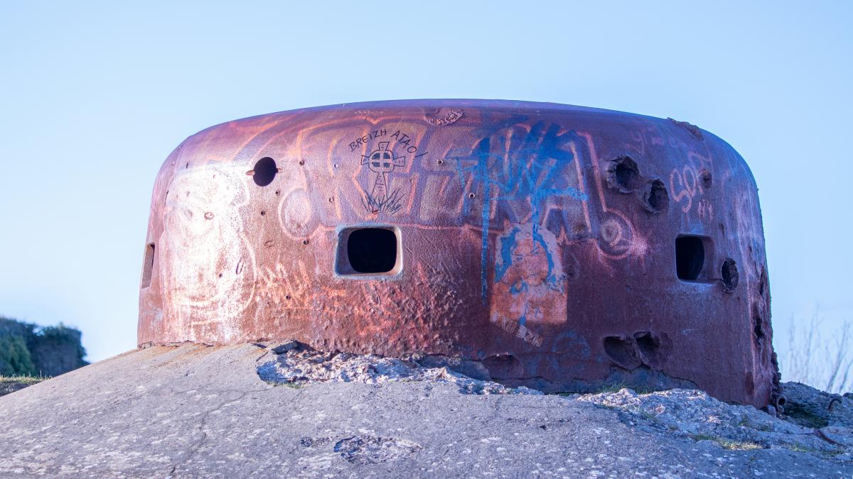 a rusted out round building with graffiti on it