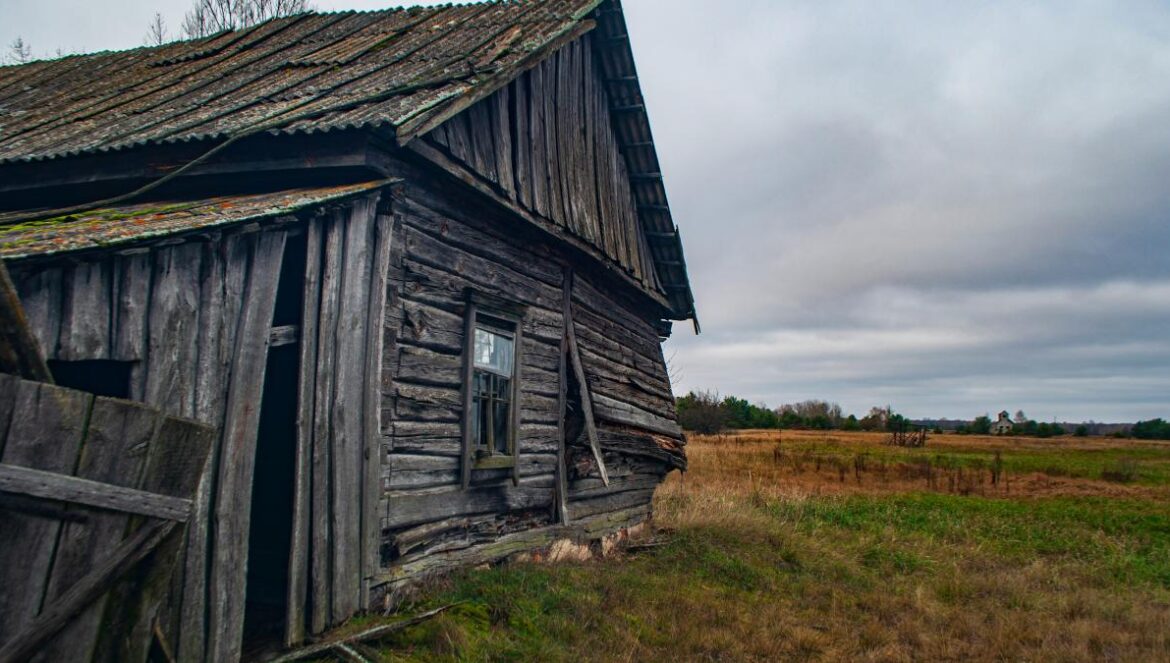 a wooden building in a field