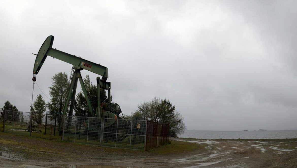 an oil pump sitting on top of a dirt field