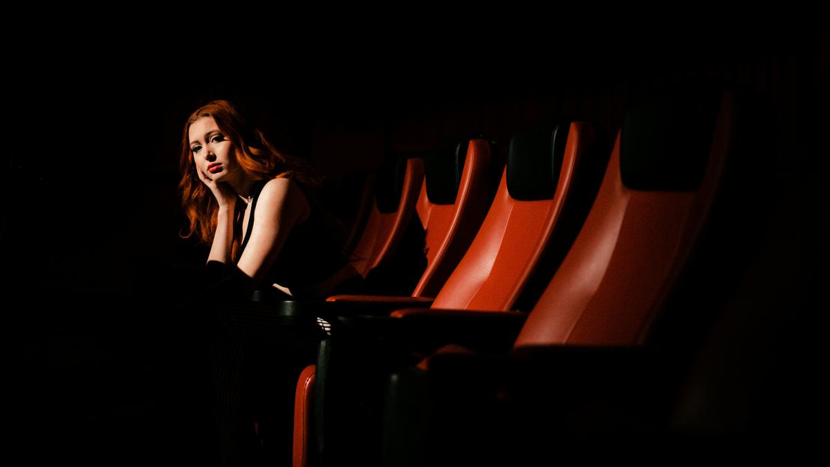 a woman sitting in a row of red chairs