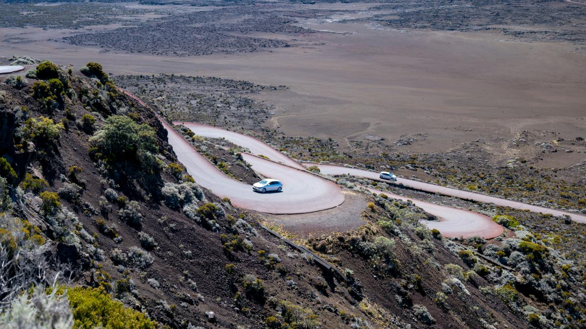 a car driving down a winding road in the mountains