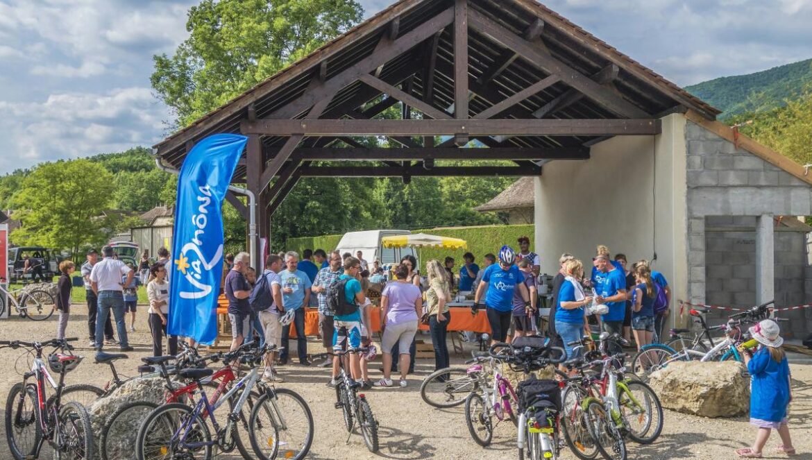 a group of people standing around a bunch of bikes