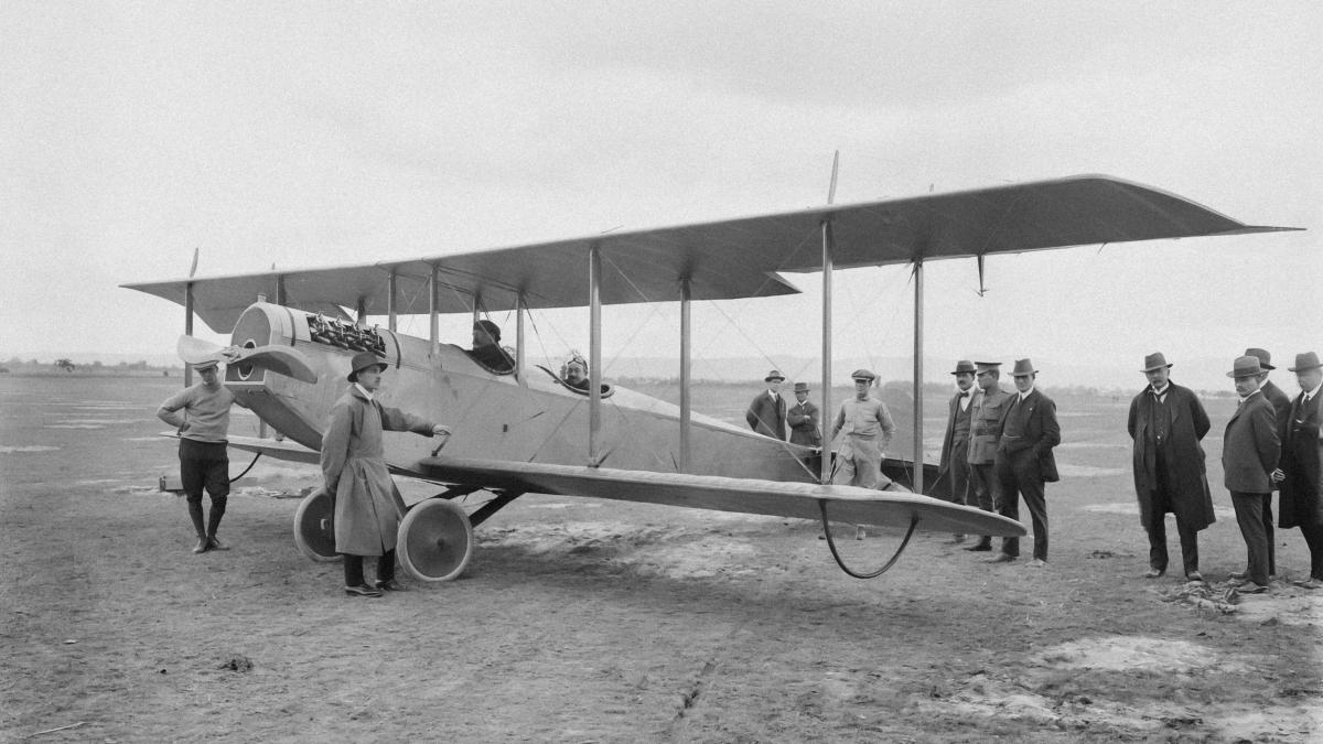 a group of people standing around a small airplane