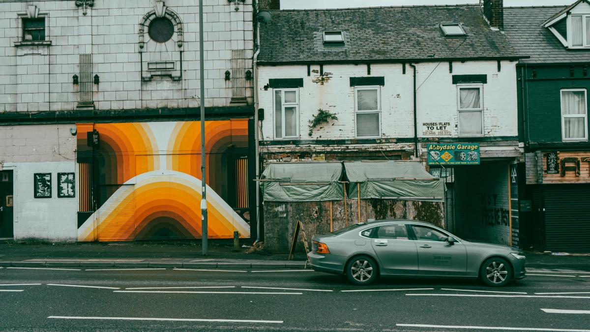 a car parked on the side of a road next to a building