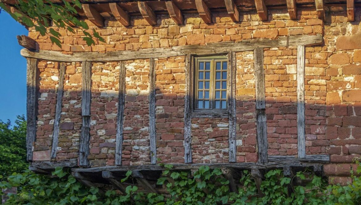 an old brick building with a window and a balcony