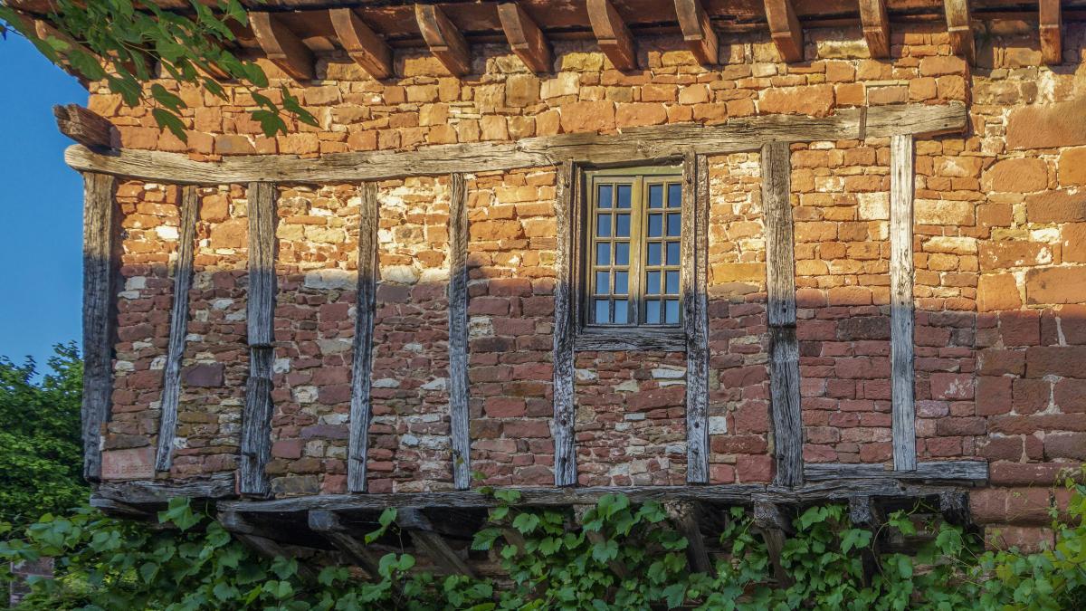 an old brick building with a window and a balcony