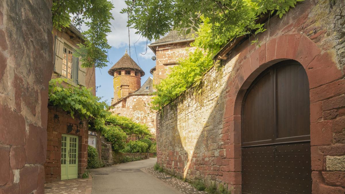 an alley way with a gate and a tower in the background