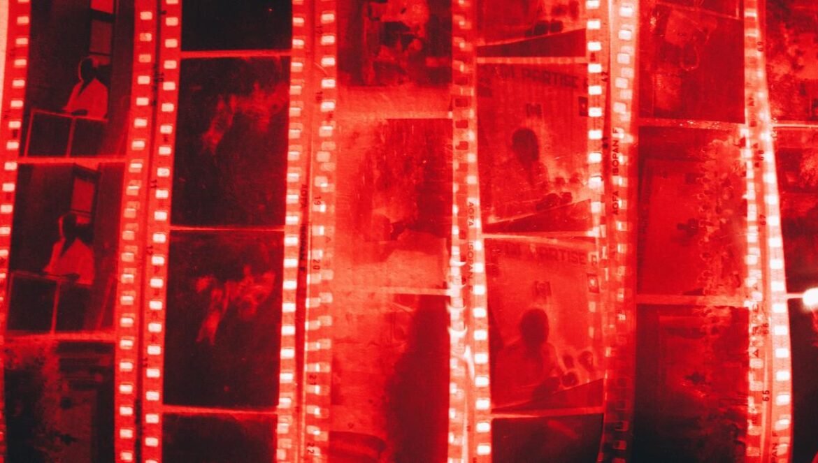 a man standing in front of a wall of film