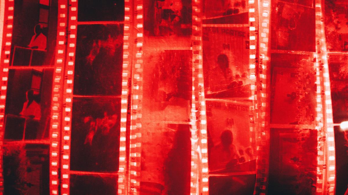 a man standing in front of a wall of film