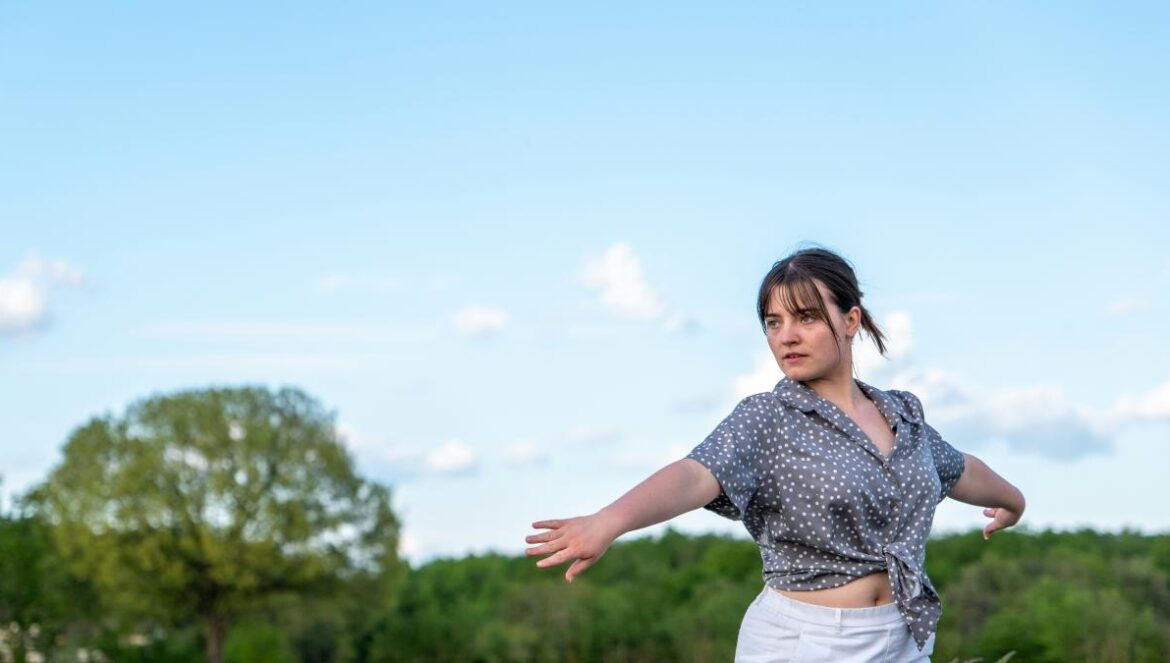 a woman is throwing a frisbee in a field