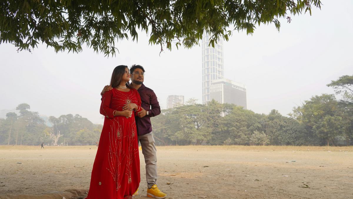 a man and a woman standing under a tree