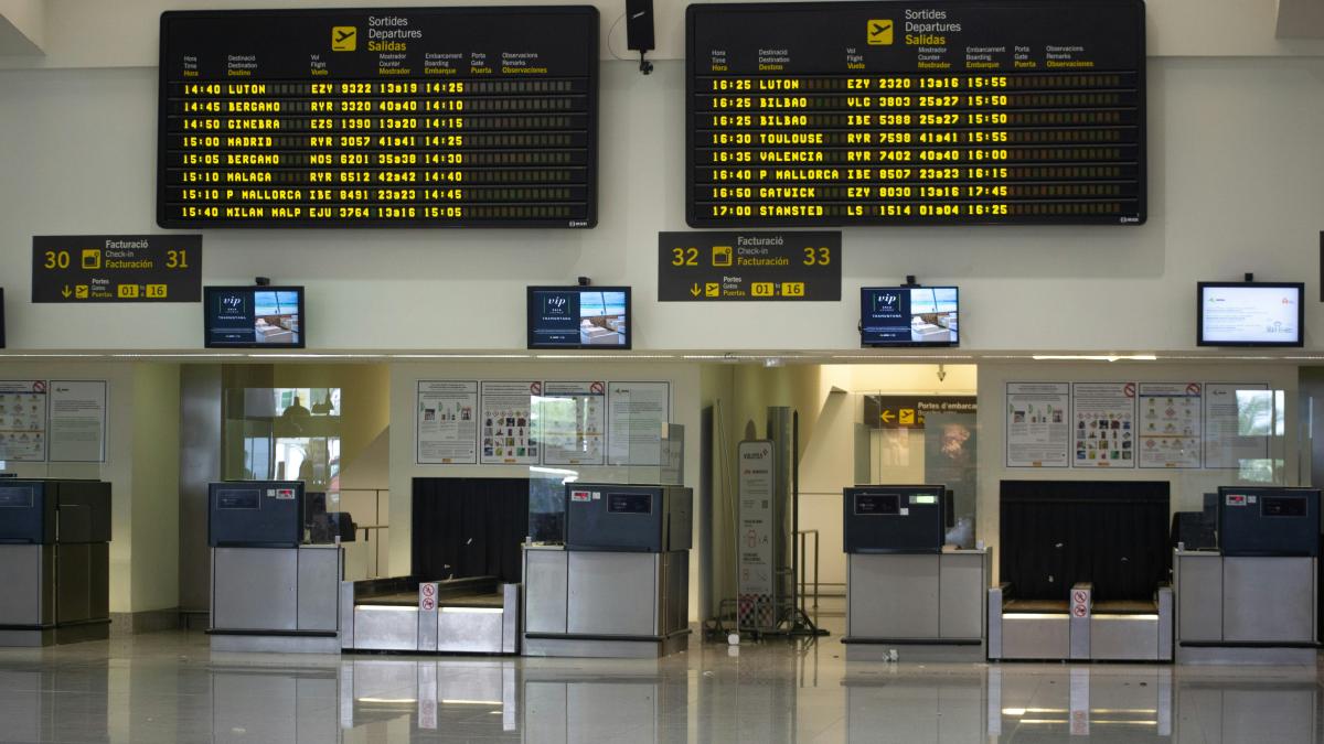 an airport terminal with a lot of electronic screens