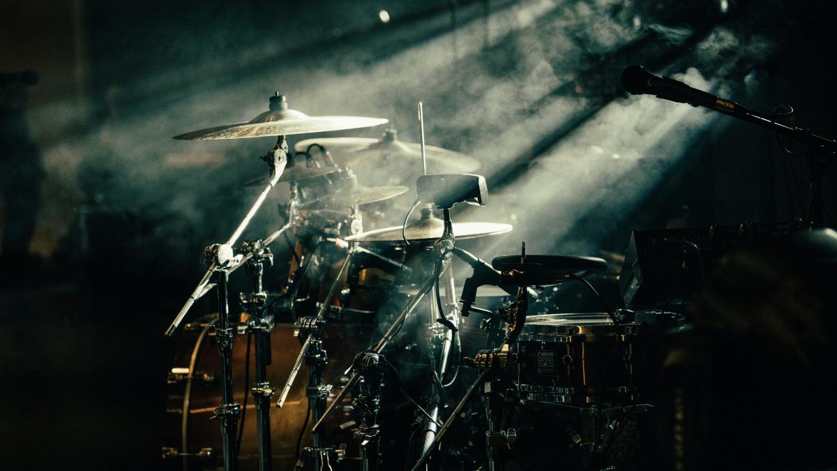 a drum set up in front of a stage light