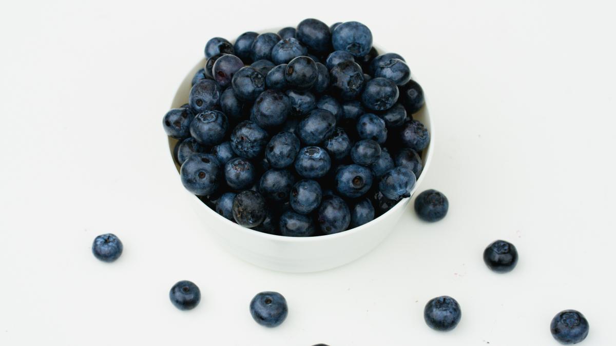 a white bowl filled with blueberries on top of a table
