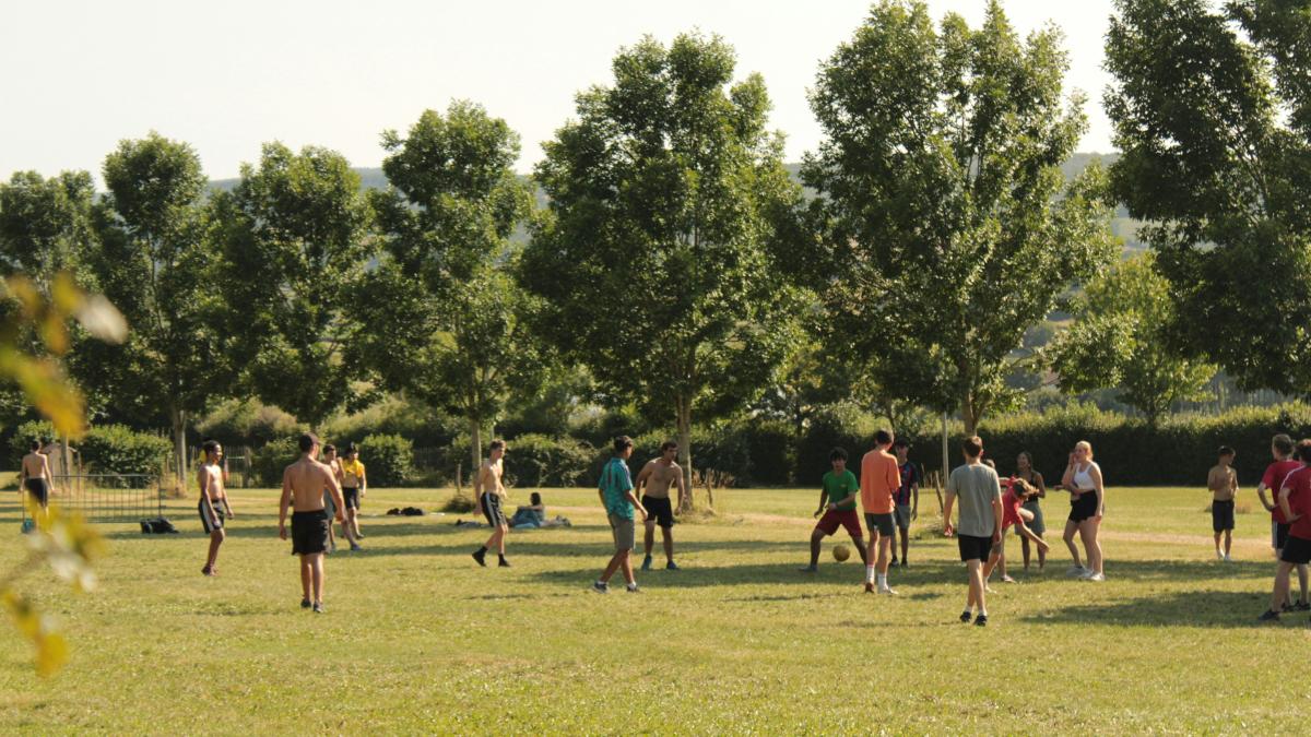 a group of people standing on top of a lush green field