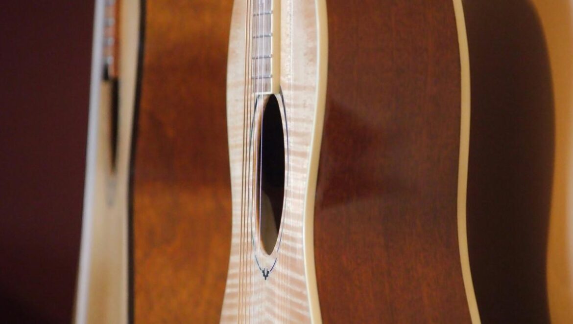 a close up of a guitar with a wooden back and sides