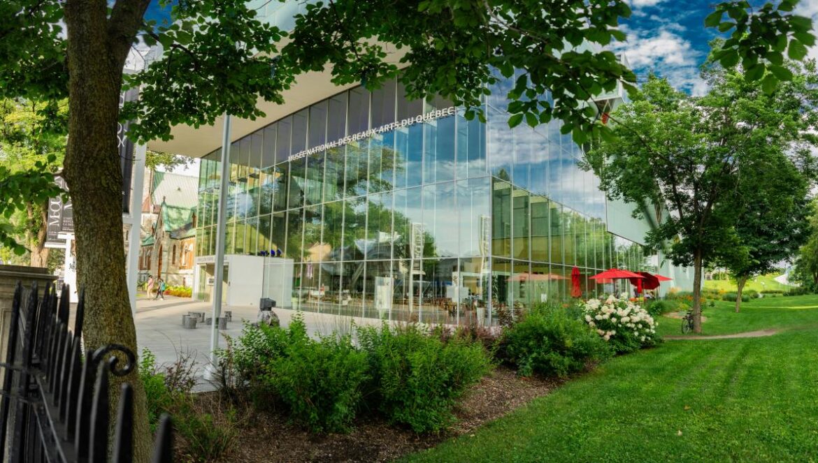 a large glass building with a red umbrella in front of it