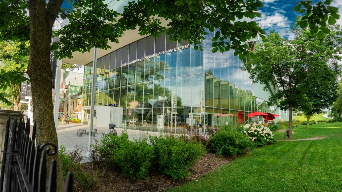 a large glass building with a red umbrella in front of it