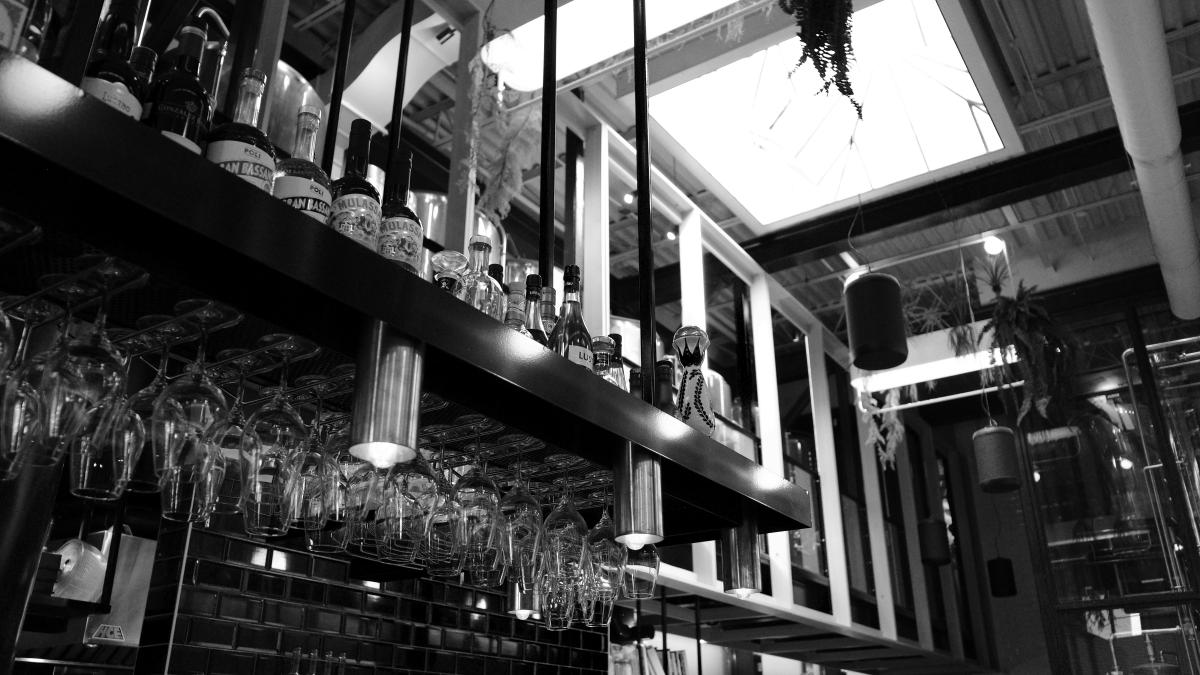 a black and white photo of a bar filled with wine glasses