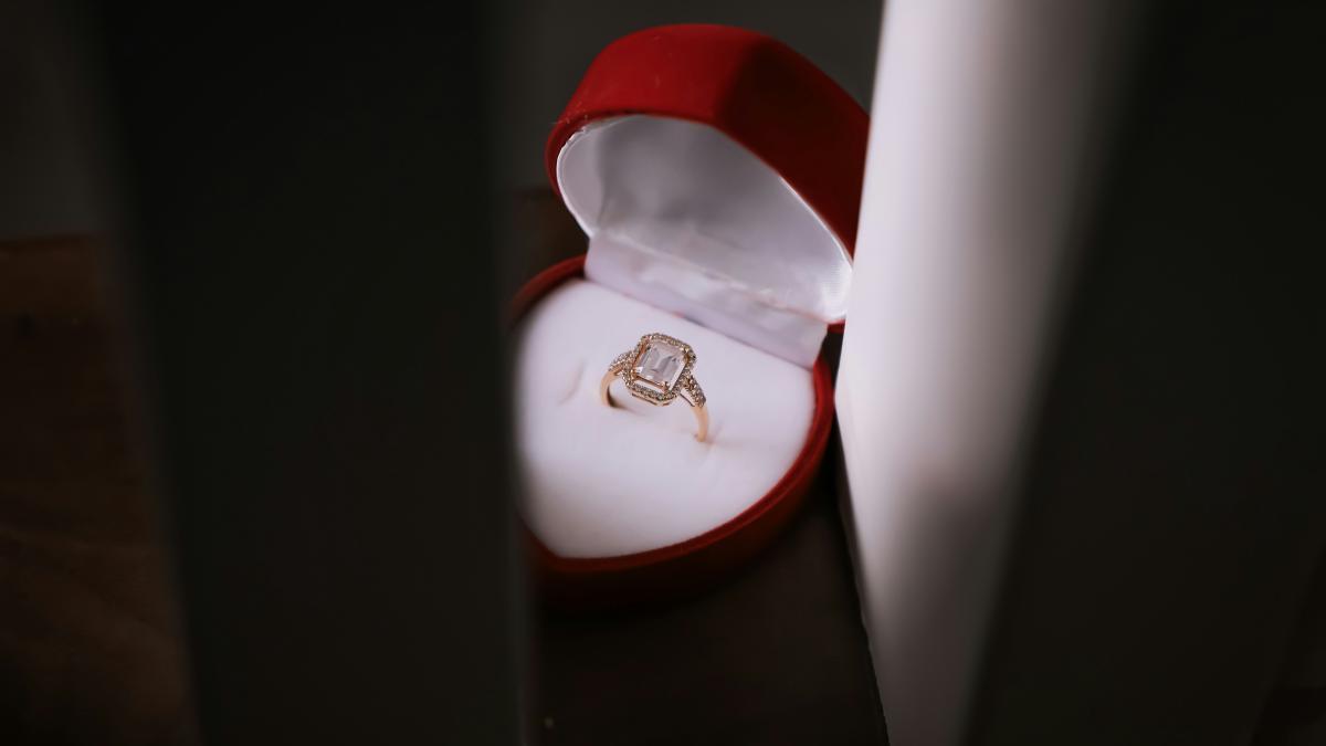 a ring sits in a red box on a table