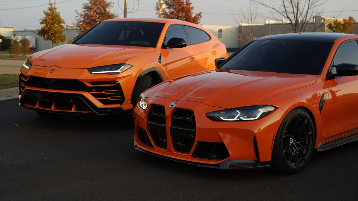 two orange sports cars parked next to each other