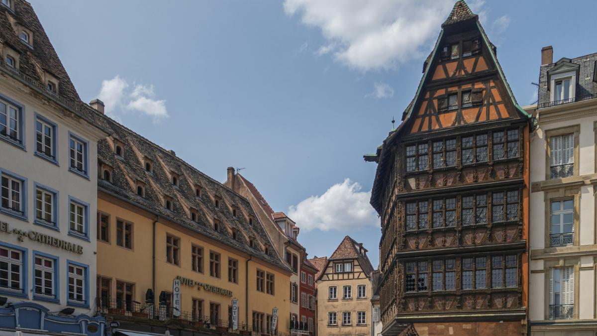a group of people walking down a street next to tall buildings