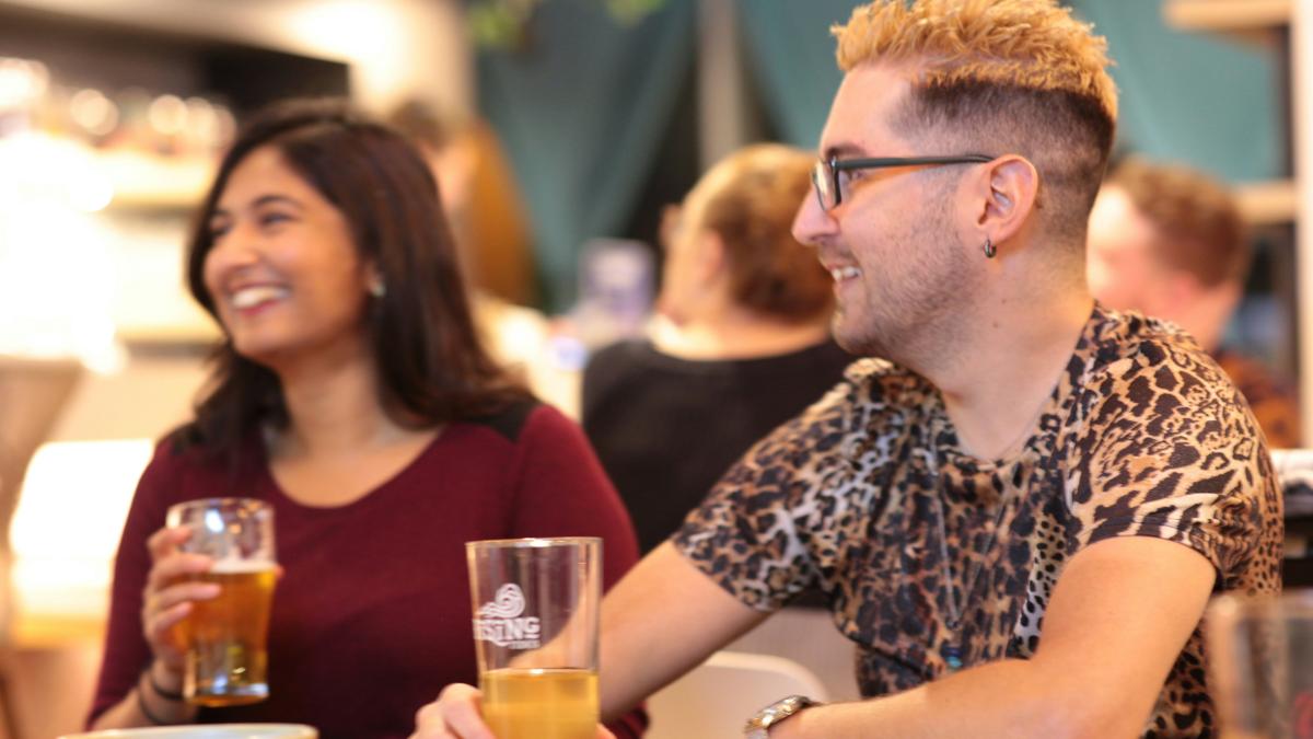a man and a woman sitting at a table with drinks