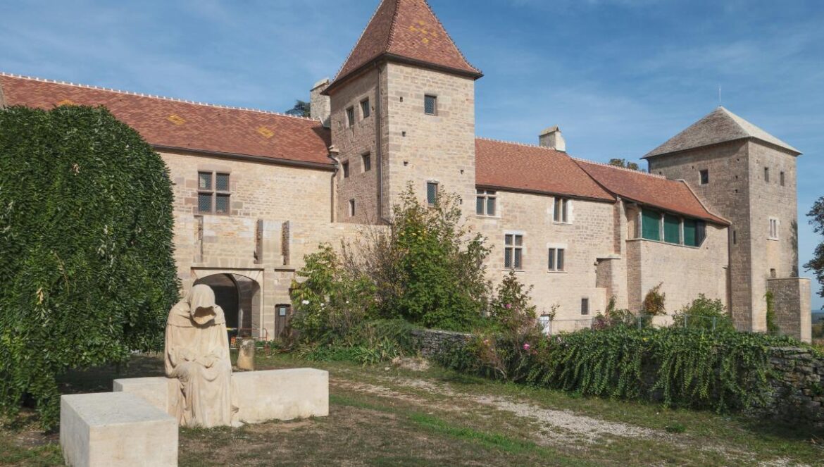 a large building with a tower and a statue in front of it