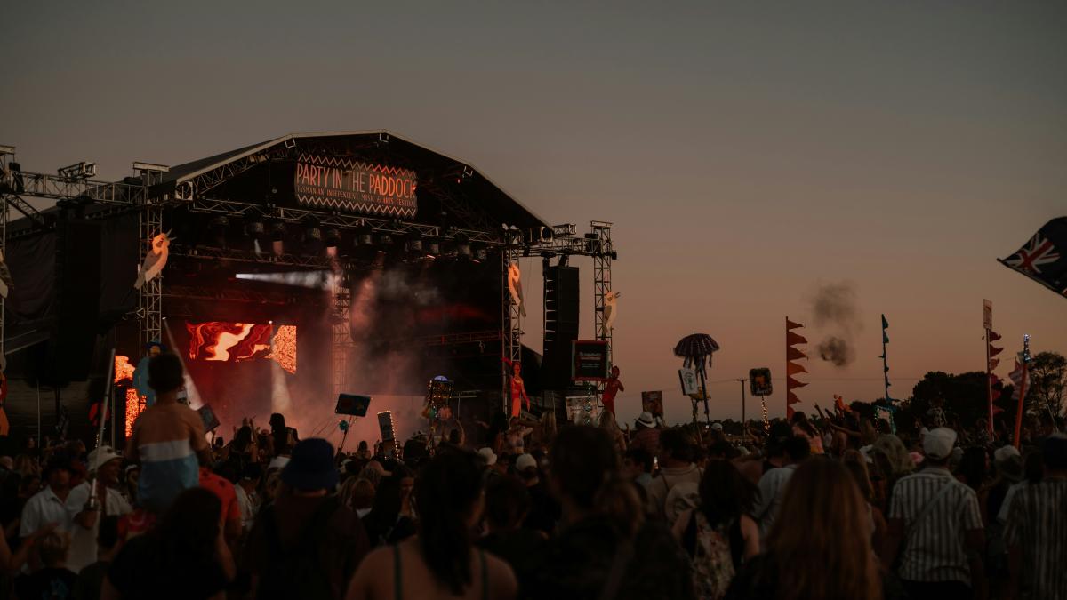 a crowd of people standing around a stage
