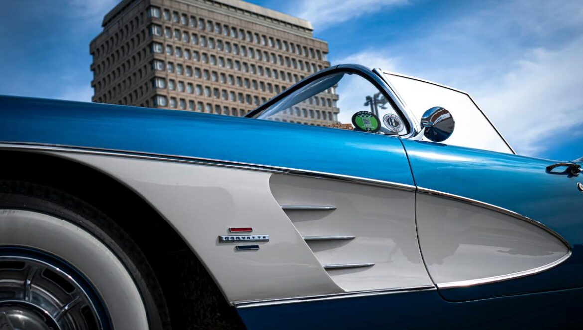 a blue and white car parked in front of a tall building
