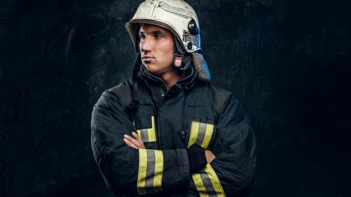 a man in a fireman's uniform with his arms crossed