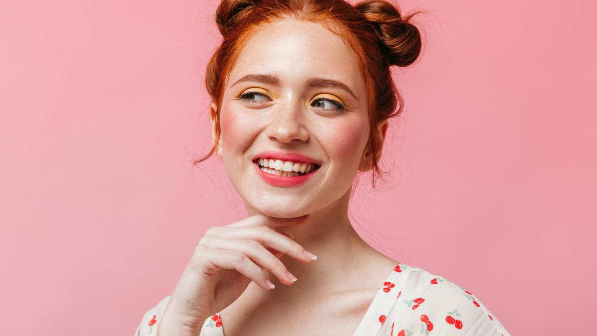 a woman with red hair is smiling and posing for a picture