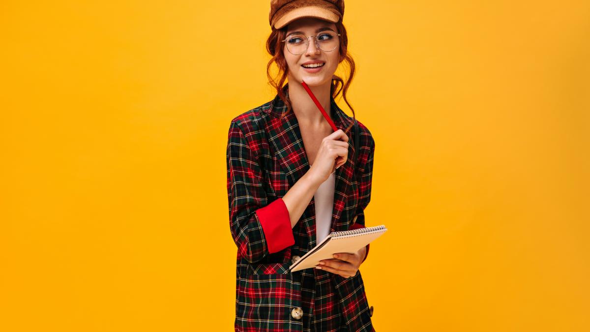 a woman holding a book and a pen in her hand