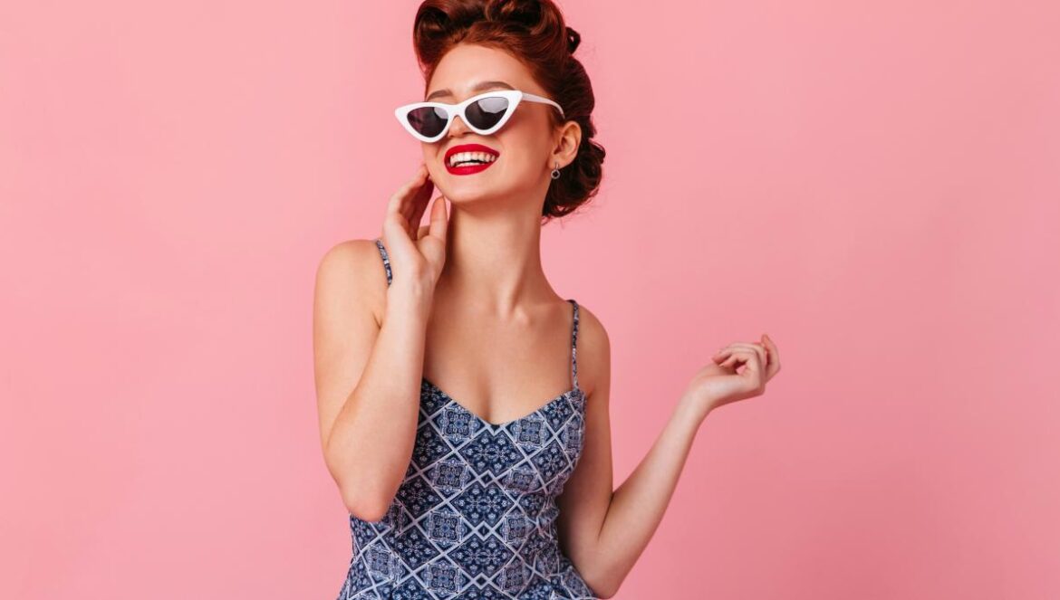 a woman in a blue dress and white sunglasses
