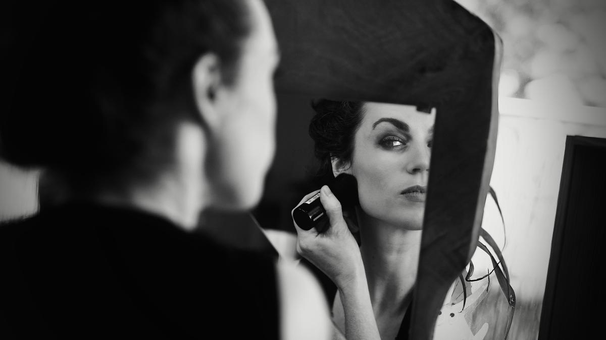 a woman is looking into a mirror while brushing her hair