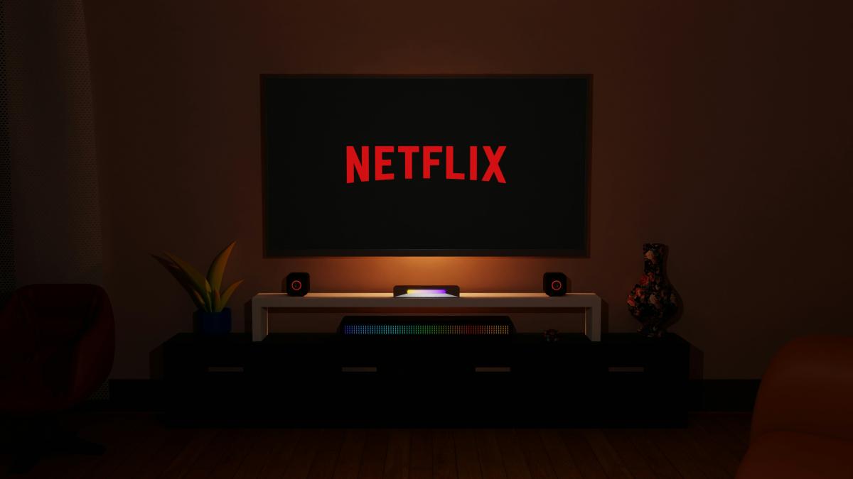 a dark room with a television and a neon netflix sign