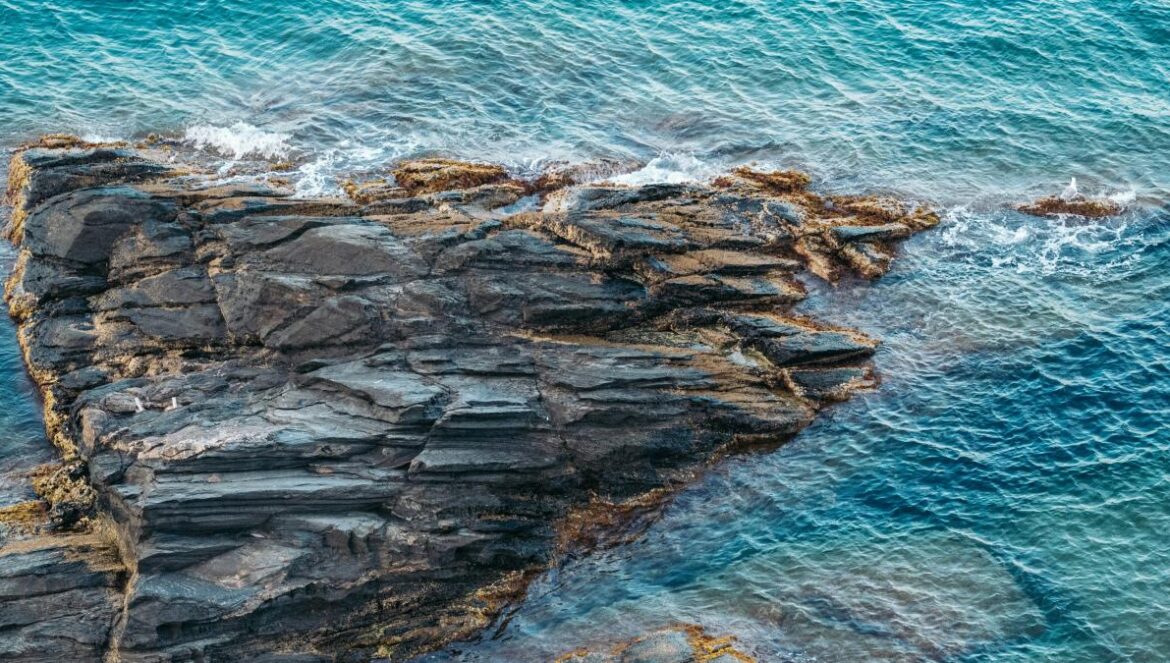an aerial view of a rock formation in the ocean