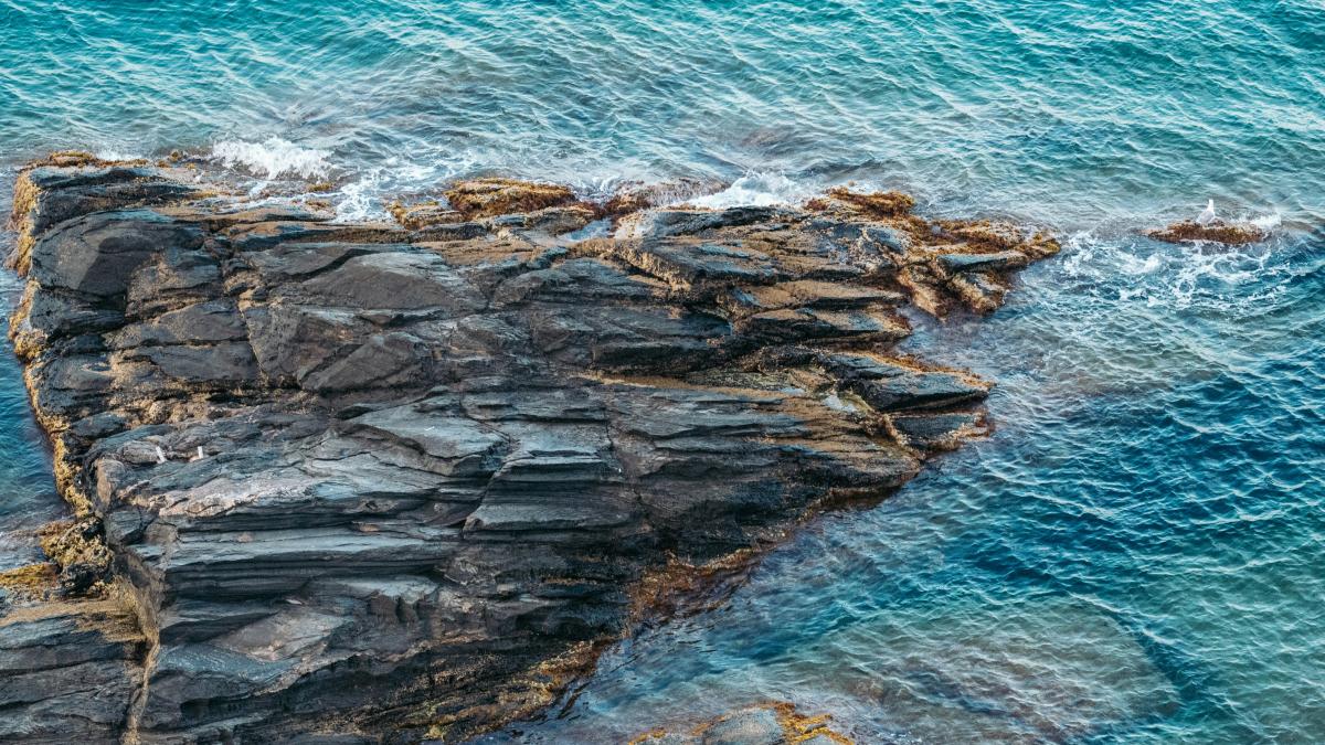 an aerial view of a rock formation in the ocean